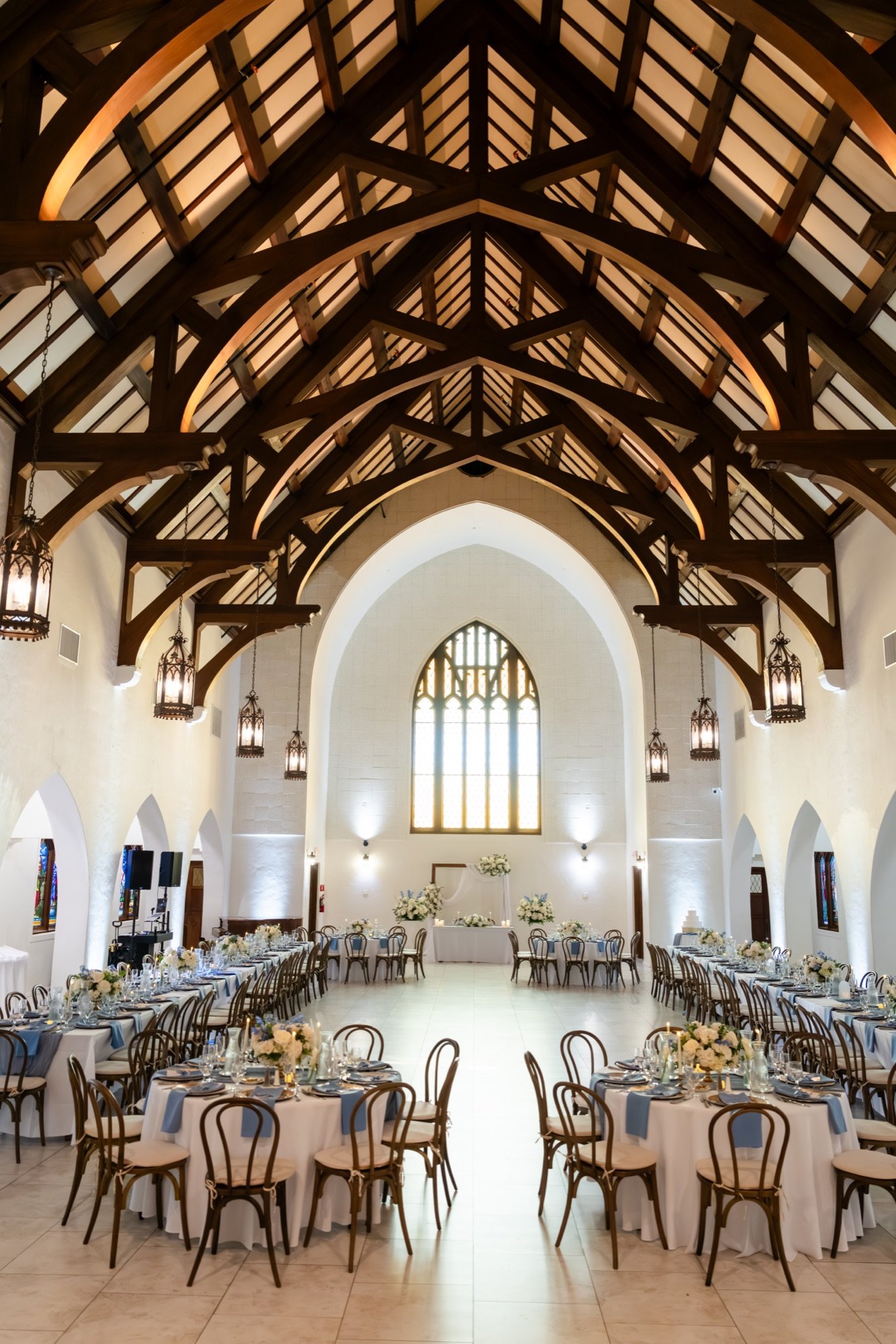 The reception hall set with long tables beneath dark wood ceiling trusses